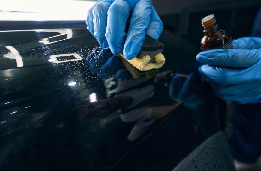 Repairman applying ceramic coating to car surface
