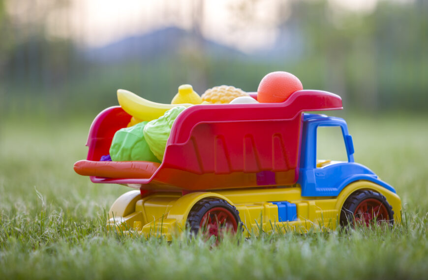 Bright plastic colorful toy car truck carrying basket with toy fruits and vegetables