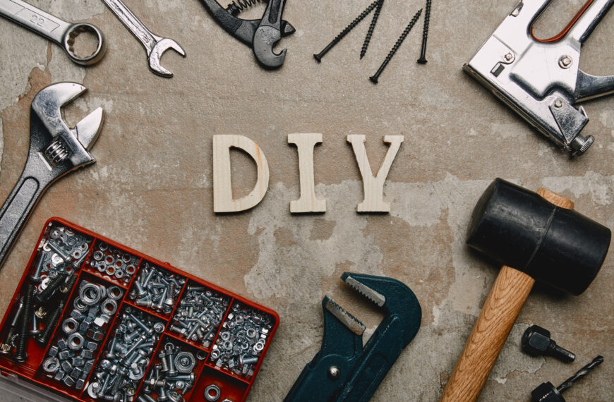 Top view of do it yourself sign and various carpentry tools arranged on old surface background